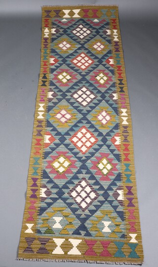 A green and white ground Maiman Kilim runner with all over diamond design 286cm x 80cm 