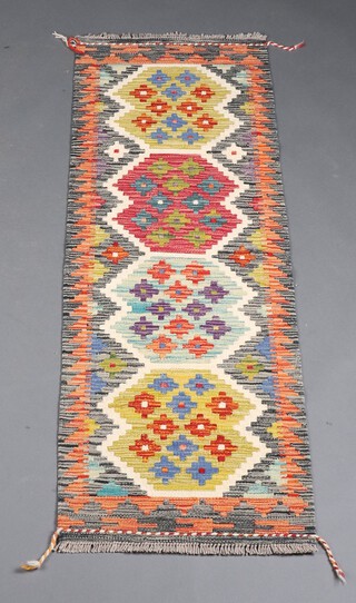 An orange, green and brown ground Chobi Kilim runner with 4 stylised medallions to the centre 151cm x 51cm 