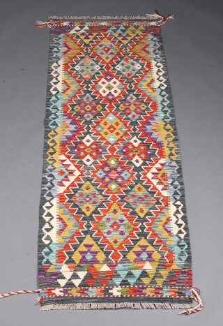 A black, green and brown ground Chobi Kilim runner with all over diamond design 189cm x 67cm 