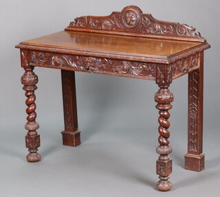 A Victorian heavily carved oak side table, the raised back carved lion mask, fitted a drawer, raised on spiral turned supports 103cm h x 113cm w x 54cm d 