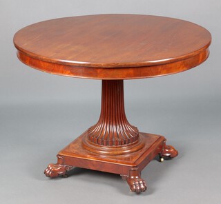 A Regency style circular mahogany pedestal centre table, raised on turned and fluted column with square base and paw feet 74cm h x 101cm diam. 