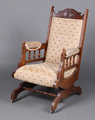 A Victorian carved mahogany rocking chair with upholstered seat and back 100cm h x 62cm w x 50cm d