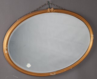 An Edwardian oval bevelled plate wall mirror contained in a gilt reeded plaster frame surmounted by a garland 55cm h x 80cm w (a/f)