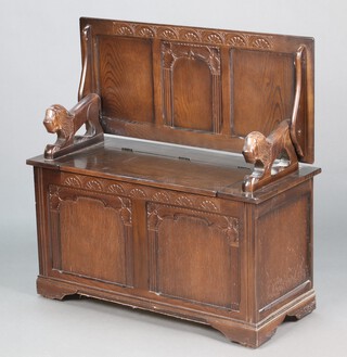 A carved oak monks bench with lion handles 71h x 95w x 42d