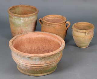 A circular terracotta garden planter 25cm h x 52cm diam, a twin handled terracotta urn 29cm h x 26cm diam together with two others 22cm h x 23cm diam and 34cm h x 33cm diam