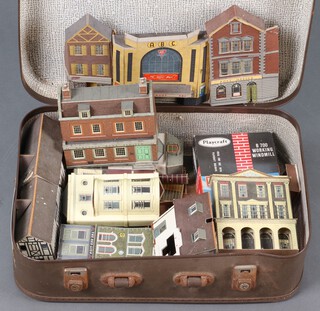 A small case contains a collection of cardboard model railway buildings