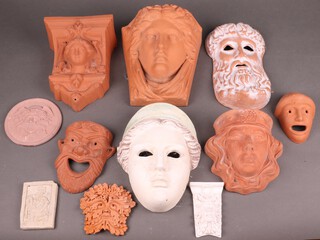 A terracotta wall mask of a lady's face, five other wall masks etc