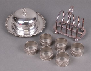 A circular silver plated butter dish with glass liner, six silver plated napkin rings and a silver plated 5 bar toast rack