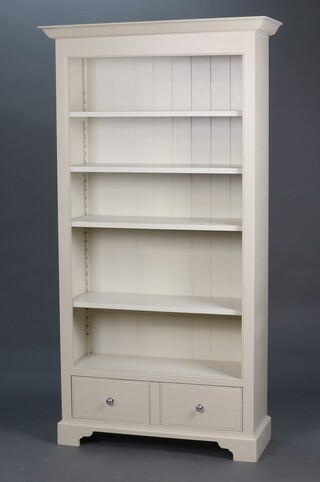Neptune, a cream painted open bookcase with moulded cornice and fitted adjustable shelves, the base fitted a drawer and raised on bracket feet 210h x 112w x 42d