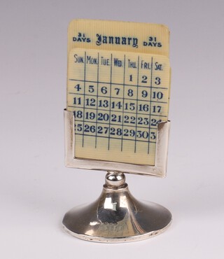 A silver perpetual calendar, raised on a circular foot, London 1919 by H Pidduck & Sons, makers marks rubbed, 6cm, complete with 3 double sided month cards and 3 double sided calendar cards