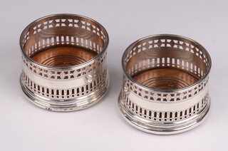 A pair of George III circular pierced silver miniature bottle coasters with turned wooden bases, London 1789 by Hester Bateman, 4cm h x 6cm diam. 