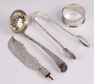 A William IV engraved silver Old English pattern sifter spoon, London 1837, a Victorian silver bladed butter knife Birmingham 1865, a pair of silver sugar tongs Sheffield 1912 by Mappin & Webb and a silver napkin ring Birmingham 1957,  126 grams  