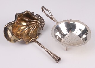 A silver tea strainer on panel supports, Birmingham 1960, together with a Continental silver scallop shaped ladle head, 56 grams 