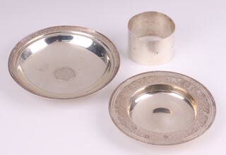 A circular silver Armada dish London 1978 by William Comyns & Sons Ltd. 9.5cm, a 925 planished silver napkin ring and a Continental silver dish set a coin 10cm, 163 grams 