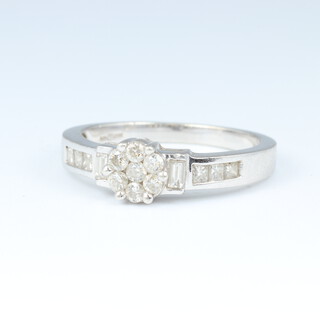 A 9ct white gold 6 stone diamond cluster ring, set 2 baguette diamonds and 6 square cut diamonds to the shoulders, size M 1/2,  2.9 grams 