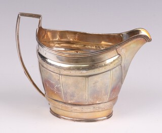 A George III oval silver cream jug with panelled and engraved decoration London 1804, makers marks rubbed, possibly Peter William and Anne Bateman, 137 grams 