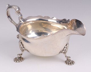 A Georgian style silver sauce boat with wavy border, C scroll handle and hoof supports, Birmingham 1929 by Adie Brothers Ltd., 304 grams  