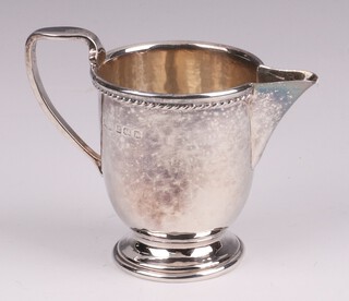 A circular planished silver cream jug Birmingham 1925, by Albert Ernest Jenkins, marks rubbed, 6cm, 63 grams  