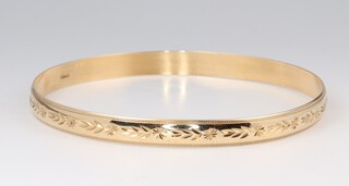 A 9ct yellow engraved gold bangle, 7cm diam. 10.2 grams 
