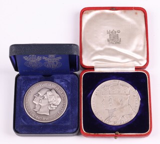 A pair of cased commemorative silver medals commemorating the 1935 Silver Jubilee of George V and the 25th Wedding Anniversary of Queen Elizabeth II and Prince Philip designed by John Pinches, 149.5 grams  