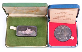 A silver commemorative medal from the Queen's Silver Jubilee together with a silver ingot depicting Windsor Castle, both in presentation cases, 152.8 grams 