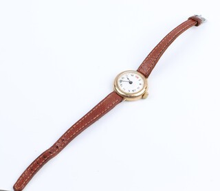 A lady's 15 jewel wristwatch with enamelled dial, Roman numerals contained in a 9ct gold case with hinged back (a/f), gross weight 15.7 grams including movement, glass and leather strap 