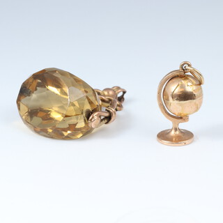 A 9ct gold charm in the form of a globe 1.8 grams together with a faceted glass seal with 9ct gold mount 