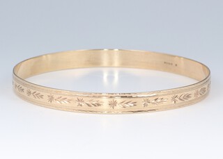 A 9ct yellow engraved gold bangle, 7cm diam., 11 grams 