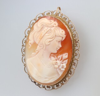 A shell carved cameo portrait brooch of a girl 4cm x 3.5cm, contained in a 9ct gold mount 