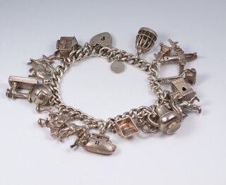 A silver curb link charm bracelet hung 19 charms, 55 grams 