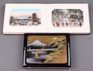 Two albums of 23 Japanese coloured postcards contained in lacquered albums 