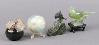 A polished green hardstone sphere 5cm, a carved hardstone figure of a wave with dolphin 5cm, a carved hardstone figure of fruit 5cm and ditto bird 