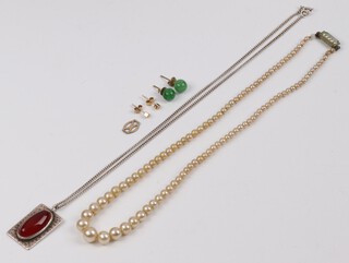 A pair of green hardstone ear studs, a silver ingot pendant set an oval hardstone on a silver chain and a string of simulated pearls 