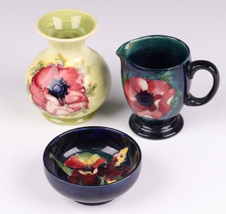 A Moorcroft yellow glazed baluster shaped vase with poppy decoration 9cm together with a green glazed pottery jug with poppy decoration 8cm, both bases impressed Moorcroft Made in England and a Moorcroft bowl 8cm 
