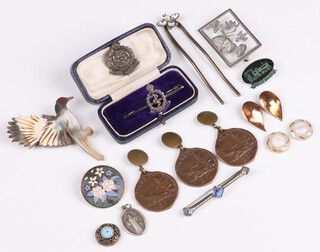 A silver and enamelled Royal Army Medical Corps sweetheart brooch, an Intelligence Corps sweetheart brooch, a rectangular pierced silver floral brooch and a carved horn brooch in the form of a bird etc