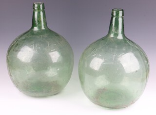 A pair of 15 litre green glass carbide bottles 41cm 
