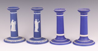 A pair of Wedgwood blue Jasper ware candlesticks decorated classical figures 16cm, 1 with firing damage to the top moulding, a pair of ditto plain blue candlesticks 15cm 