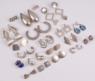 Twenty one pairs of silver earrings 