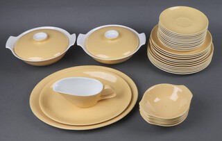 A Poole Pottery mid-Century 35 piece yellow and white glazed dinner service comprising 2 twin handled tureens and covers (1 with crazing to interior), 2 graduated meat plates, sauce boat (cracked), 6 dinner plates, 6 side plates, 6 large saucers, 6 twin handled bowls 