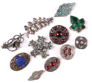 A silver filigree brooch in the form of a flower, a silver Canterbury cross brooch, a Sterling silver and marcasite set brooch together with a collection of other brooches