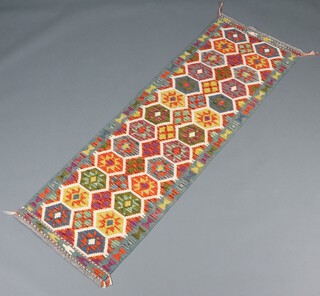 An orange and green ground Chobi Kilim runner with 2 rows of 26 hexagons to the centre 192cm x 62cm 