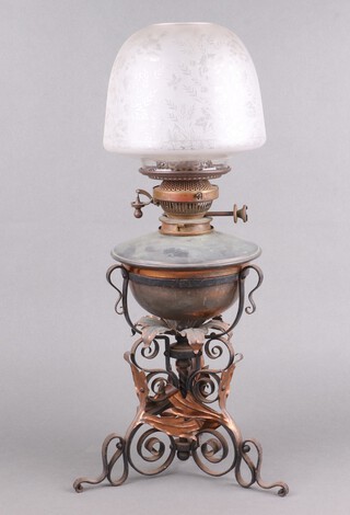 A Victorian coppered oil lamp reservoir, fitting marked maple, raised on a wrought iron and copper base, with leaf decoration 39cm, together with an etched glass shade 