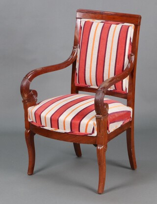 A French mahogany Empire style open armchair with carved decoration to the arms, the seat and back upholstered in striped material, raised on outswept supports 91cm h x 55cm w x 44cm d 