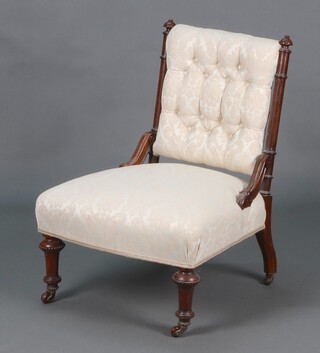 A Victorian carved walnut show frame nursing chair upholstered in white material, raised on turned supports 79cm h x 55cm w x 50cm d 
