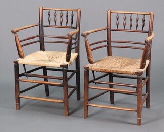William Morris, a pair of ebonised elm Sussex armchairs with spindle backs and woven rush seats, raised on turned supports 85cm h x 57cm w x 41cm d 