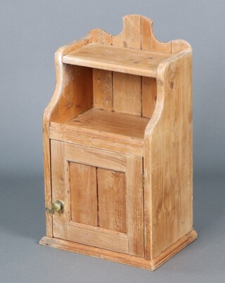 A pine hanging bathroom cabinet enclosed by a panelled door above recess 59h x 35w x 24d  