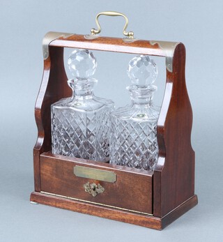 Two cut glass decanters contained in a mahogany Tantalus with presentation plaque 