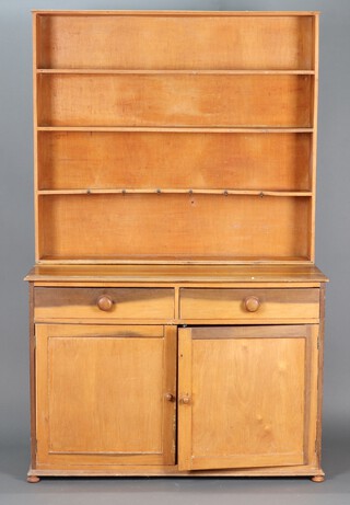 A pine dresser base fitted 2 drawers above double cupboard enclosed by panelled doors, having an associated raised back fitted 4 shelves, raised on bun feet 192cm h x 112cm w x 52cm d 