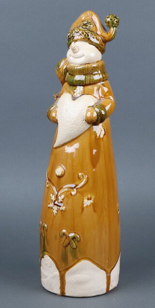 A brown glazed pottery figure of a standing clown with heart 48cm 
