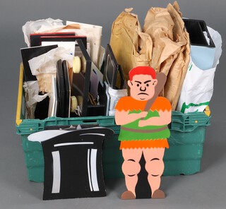 A collection of wooden magic tricks and props contained in a green plastic box